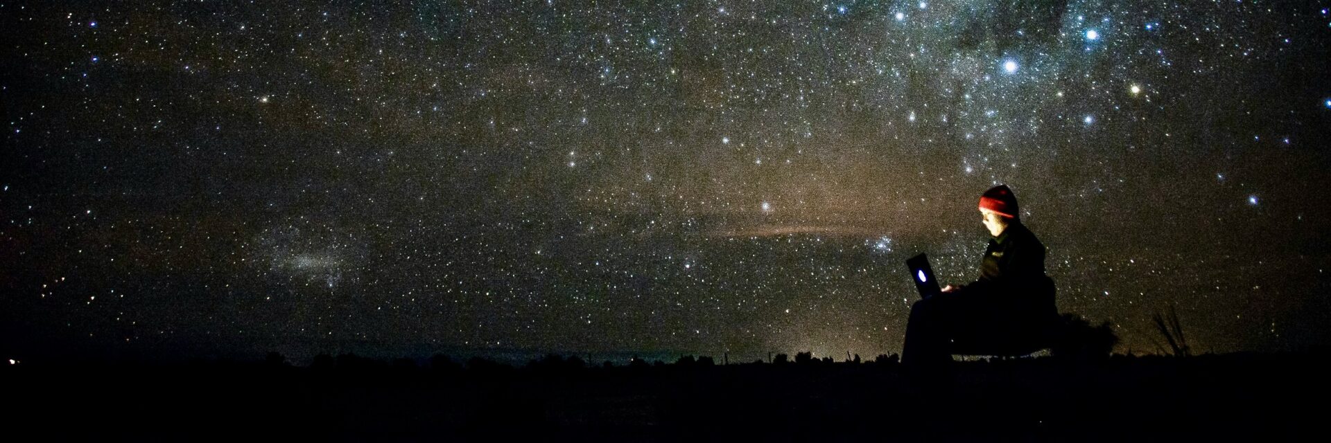 Person on laptop under stars